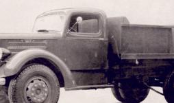 Retušovaný tovární snímek vozu Mack ER z roku 1937. Archaický řetězový pohon zadních kol a hranatá sklápěcí korba jako by ani nepatřily k mírně šípové masce s mřížkou, lehkému chromovanému nárazníku, elegantní kabině a protáhlým aerodynamickým reflektorům. I to ale byla jedna z tváří náklaďáků s buldokem na chladiči.
